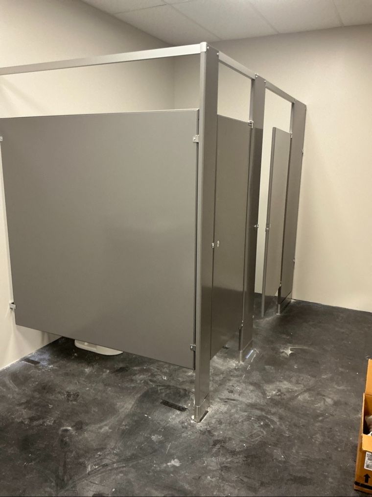 Commercial bathroom partition stalls — gray solid plastic toilet partitions with stainless steel hardware