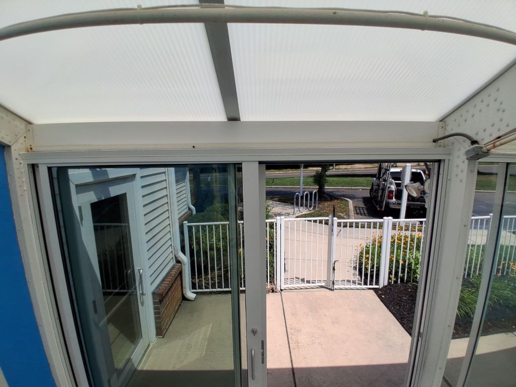 Interior view of commercial pool enclosure white sliding glass door system