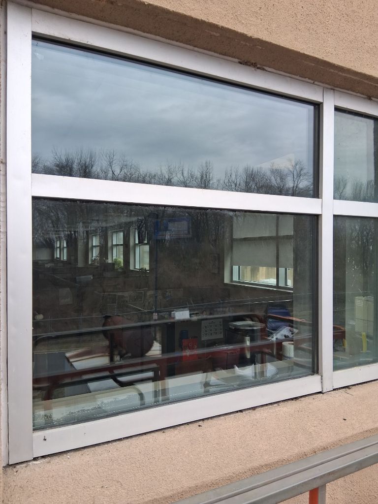 Commercial entry vestibule with dark aluminum storefront framing and glass transoms