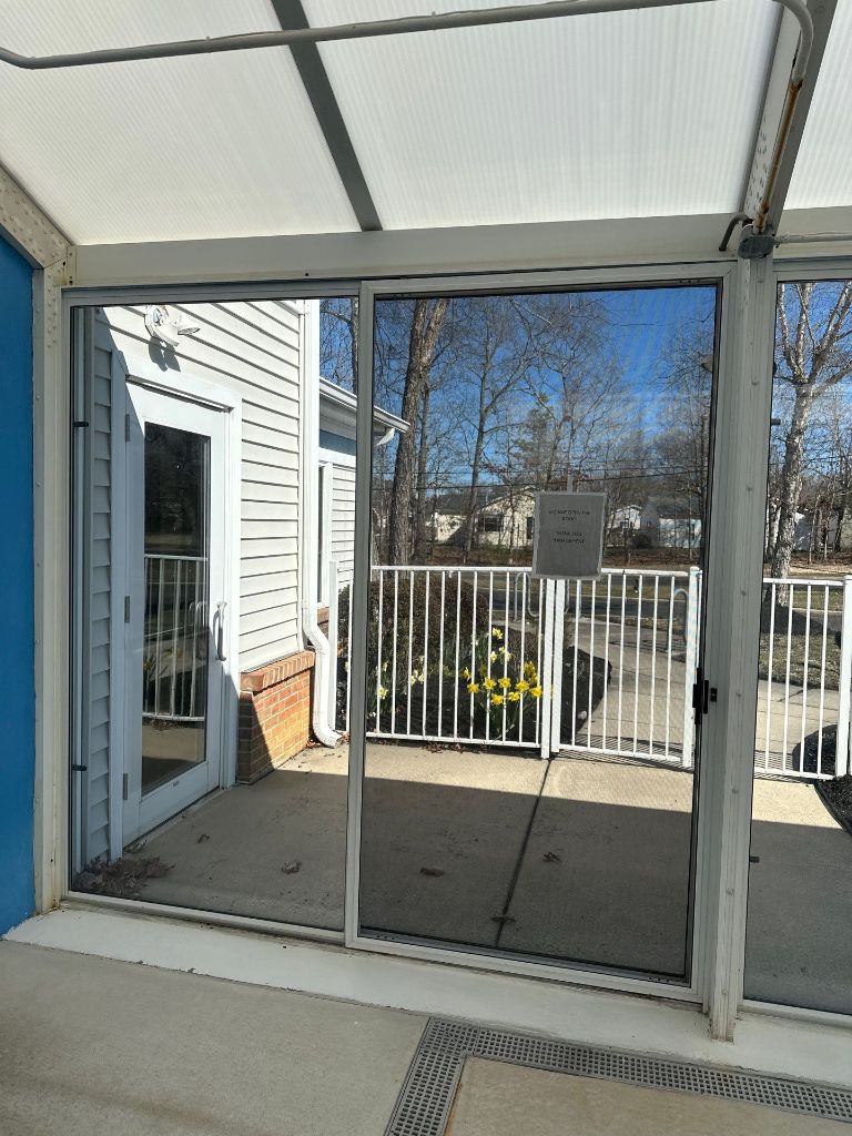 Pool enclosure sliding glass door system viewed from interior with pool visible